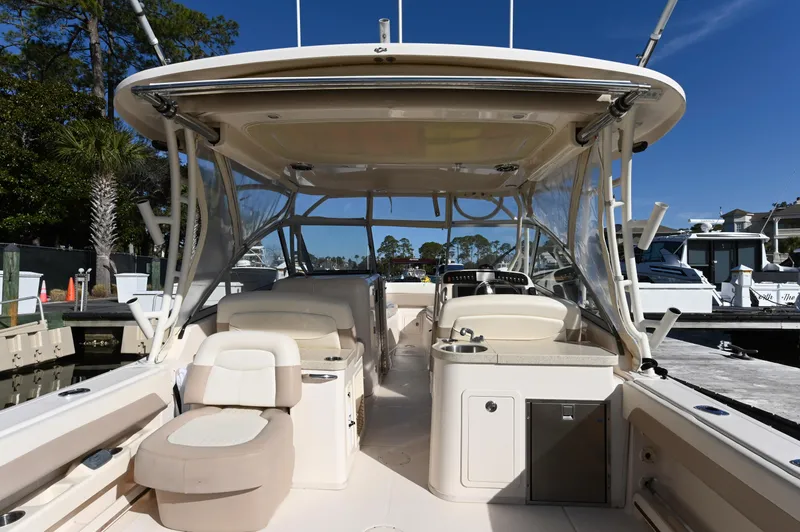 Slide: The Image of 2014 Grady-White Freedom 307 boat interior with seating and helm, docked under clear skies. - 31