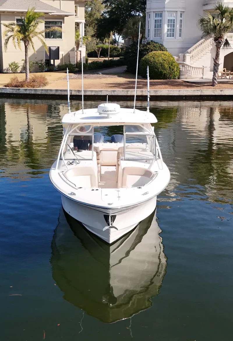 Slide: The Image of 2014 Grady-White Freedom 307 boat docked on calm water near luxury homes. - 8
