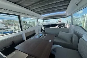 Slide: The Image of 2024 Axopar 37 XC Cross Cabin interior with modern seating and panoramic windows. - 11