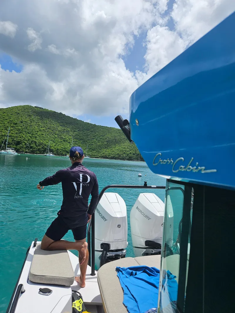 Slide: The Image of 2024 Axopar 37 Cross Cabin on serene water with lush green hills in the background. - 4