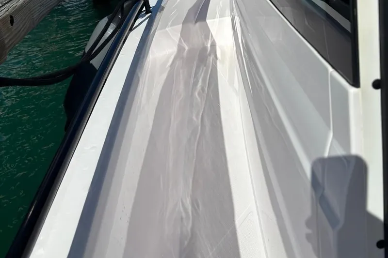 Slide: The Image of 2024 Axopar 37 Cross Cabin deck view with sleek white finish. - 7