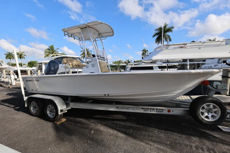 Slide: The Image of 2022 Sportsman Masters 207 Bay Boat on trailer, parked near yachts and palm trees. - 25