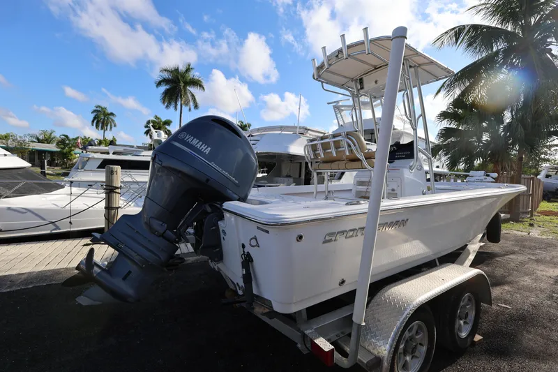 Slide: The Image of 2022 Sportsman Masters 207 Bay Boat on trailer, dockside with palm trees and yachts. - 27