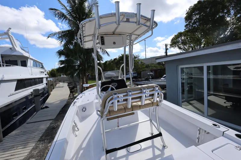 Slide: The Image of 2022 Sportsman Masters 207 Bay Boat docked, featuring T-top and console, surrounded by palm trees. - 33