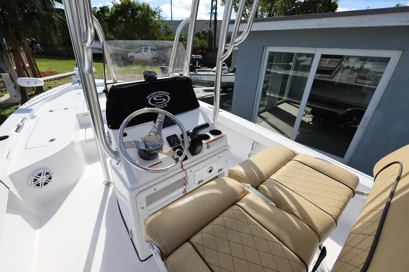 Slide: The Image of 2022 Sportsman Masters 207 Bay Boat interior with helm, steering wheel, and cushioned seating. - 35