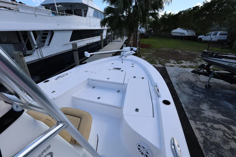 Slide: The Image of 2022 Sportsman Masters 207 Bay Boat docked near larger yacht, surrounded by greenery. - 39