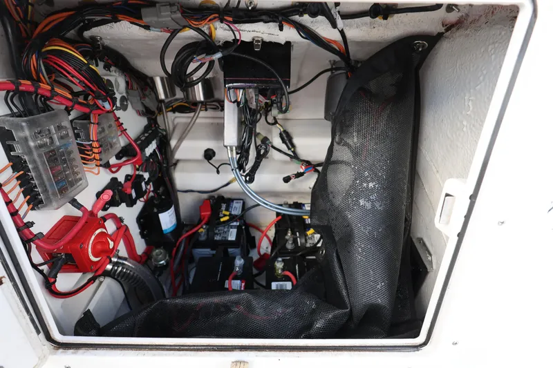 Slide: The Image of 2022 Sportsman Masters 207 Bay Boat electrical compartment with wiring and battery setup. - 43