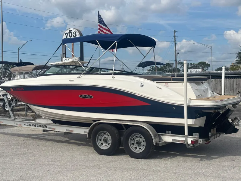 Slide: The Image of 2021 Sea Ray SPX 230 boat on trailer, red and white design, parked outdoors. - 1