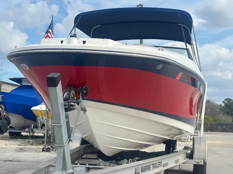 Slide: The Image of 2021 Sea Ray SPX 230 boat on trailer, red and white hull, American flag visible. - 10