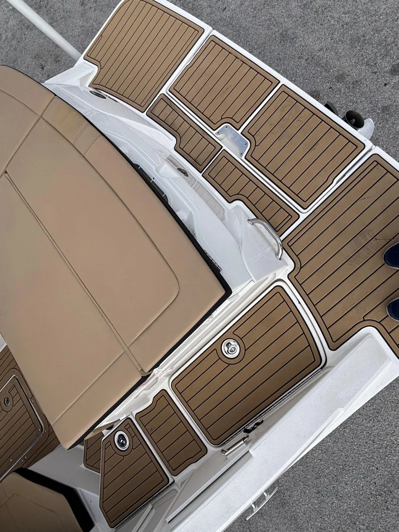 Slide: The Image of 2021 Sea Ray SPX 230 boat deck with tan seating and wood-style flooring. - 14