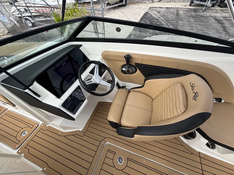 Slide: The Image of 2021 Sea Ray SPX 230 boat interior with tan leather seating and modern dashboard. - 17