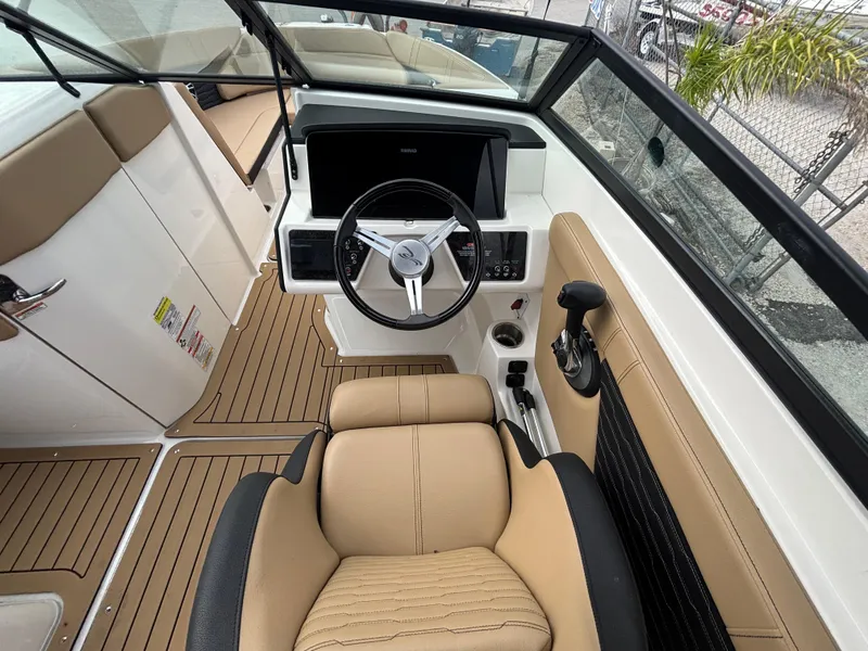 Slide: The Image of 2021 Sea Ray SPX 230 boat interior with tan seating and modern dashboard. - 18