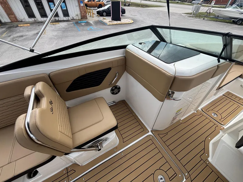 Slide: The Image of 2021 Sea Ray SPX 230 boat interior with tan seating and wood-style flooring. - 19