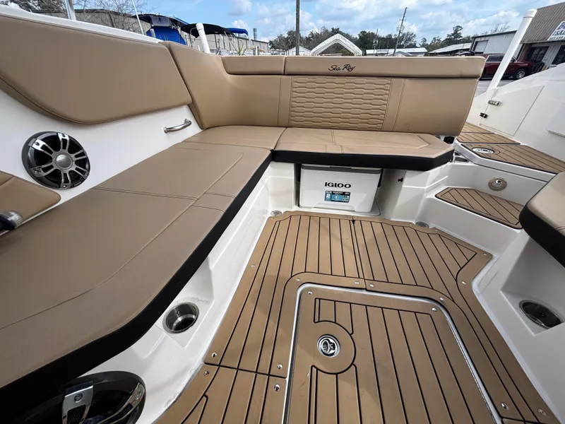 Slide: The Image of 2021 Sea Ray SPX 230 boat interior with tan seating and teak-style flooring. - 25