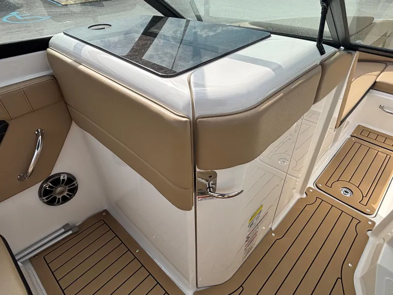 Slide: The Image of 2021 Sea Ray SPX 230 boat interior with tan upholstery and wood-style flooring. - 29