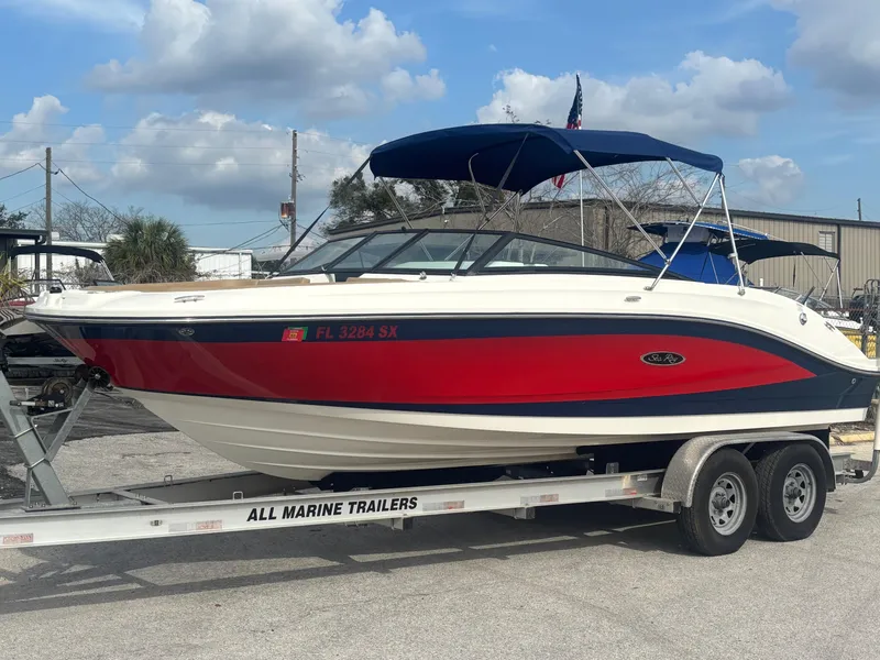 Slide: The Image of 2021 Sea Ray SPX 230 boat on trailer, red and white design, blue canopy. - 3