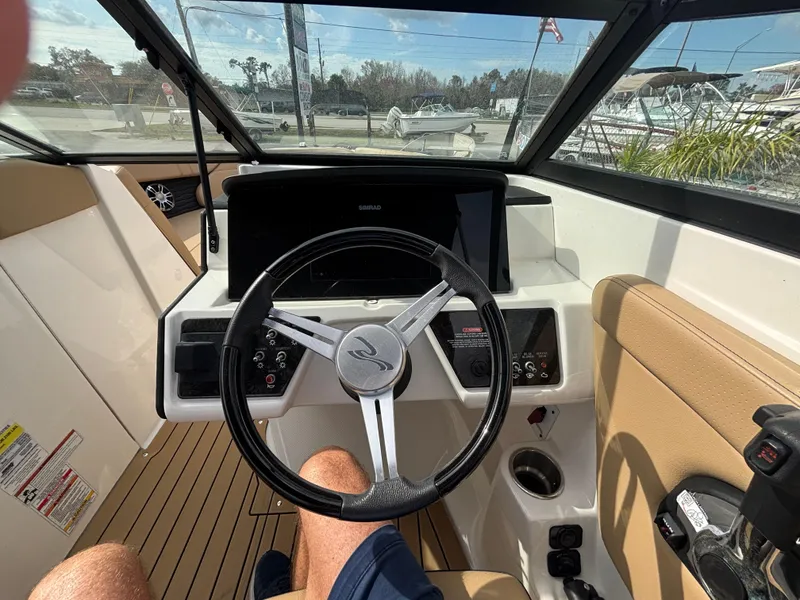 Slide: The Image of 2021 Sea Ray SPX 230 boat cockpit with steering wheel and dashboard controls. - 31