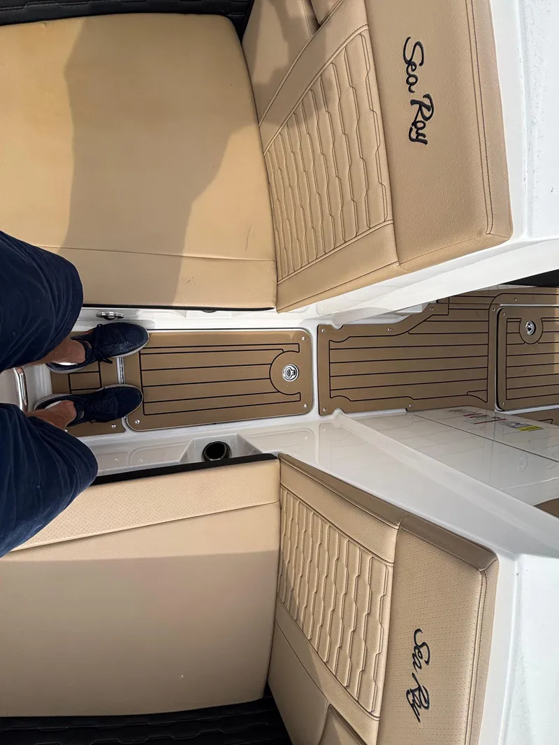 Slide: The Image of 2021 Sea Ray SPX 230 boat interior with tan seating and wood-style flooring. - 35