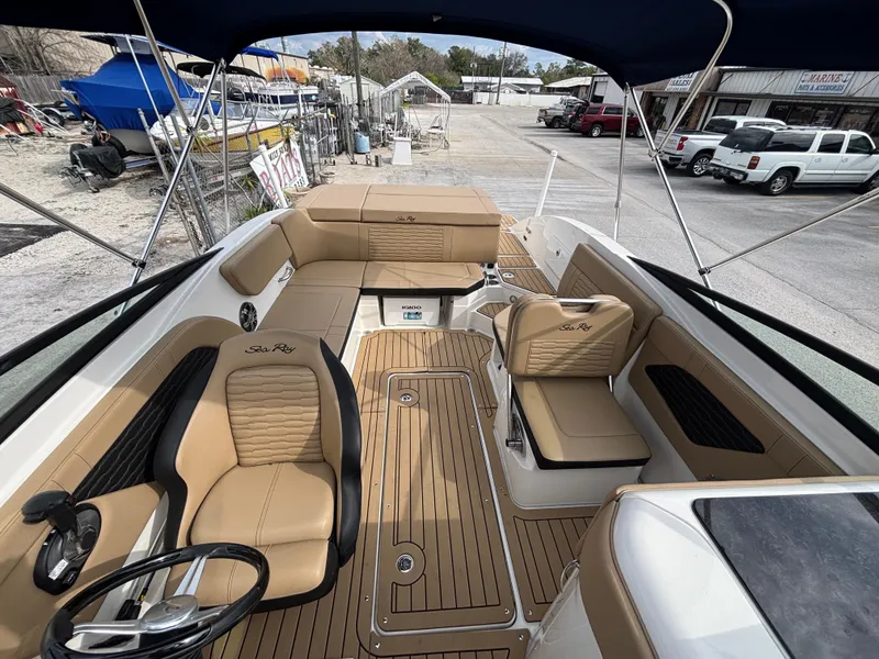 Slide: The Image of 2021 Sea Ray SPX 230 boat interior with tan seating and wood-style flooring. - 36