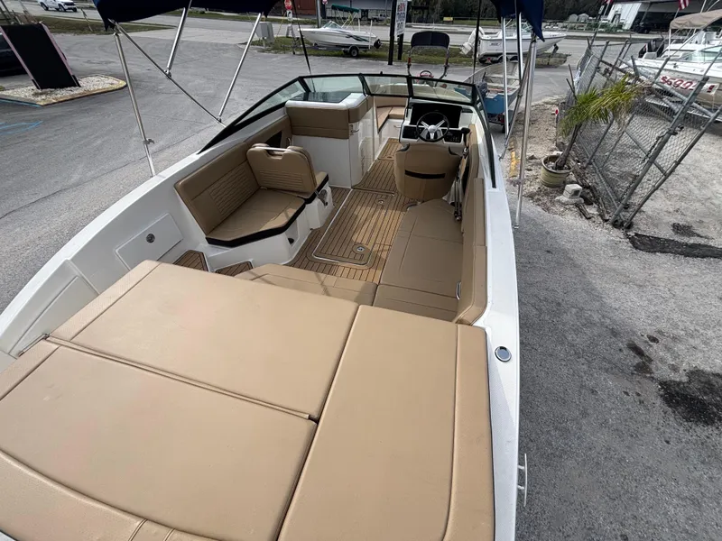 Slide: The Image of 2021 Sea Ray SPX 230 boat with tan interior, docked at a marina. - 37