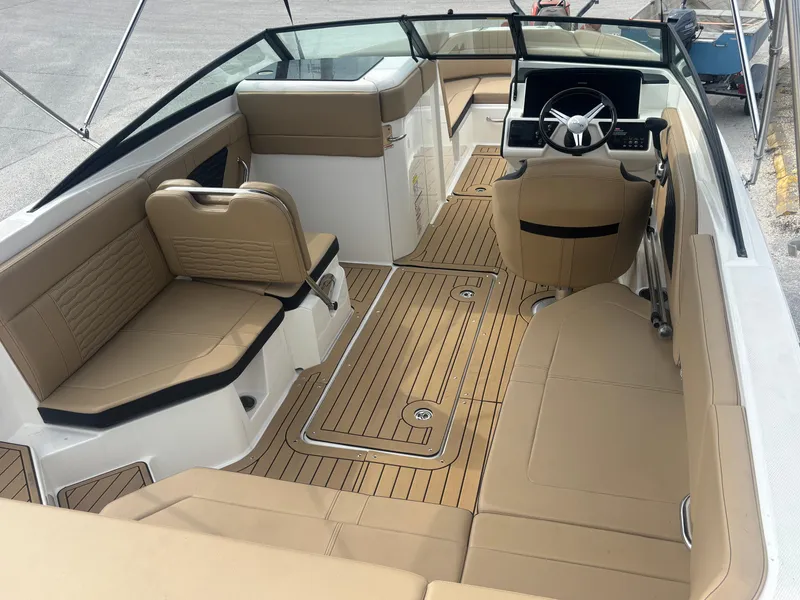 Slide: The Image of 2021 Sea Ray SPX 230 boat interior with tan seating and wood-style flooring. - 38