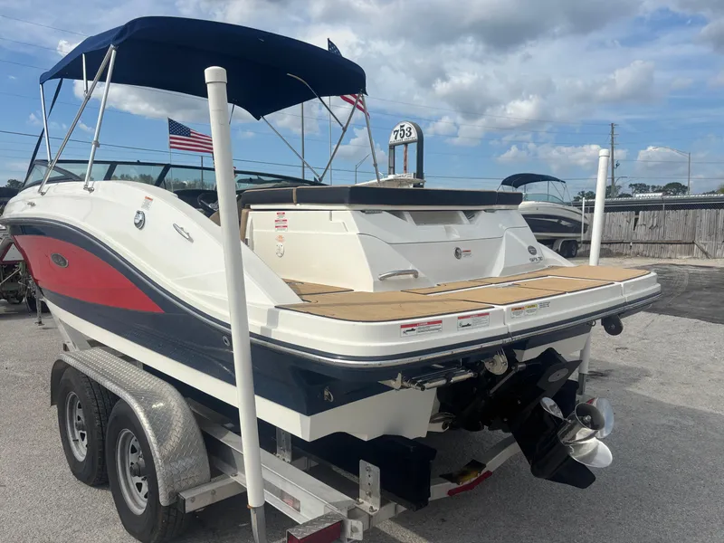 Slide: The Image of 2021 Sea Ray SPX 230 boat on trailer with blue canopy and American flag. - 4