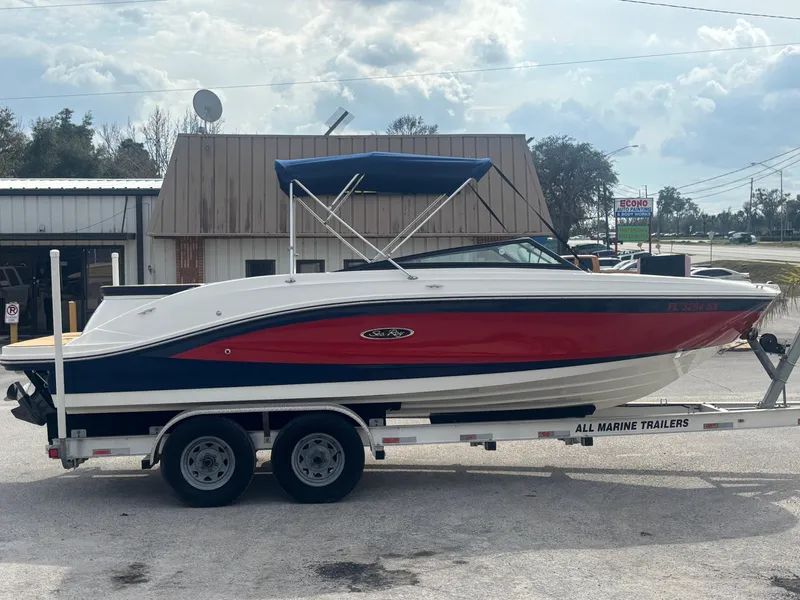 Slide: The Image of 2021 Sea Ray SPX 230 boat on trailer, red and white design, parked outdoors. - 7