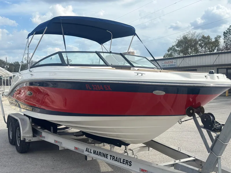 Slide: The Image of 2021 Sea Ray SPX 230 boat on trailer, red and white design, parked outdoors. - 8