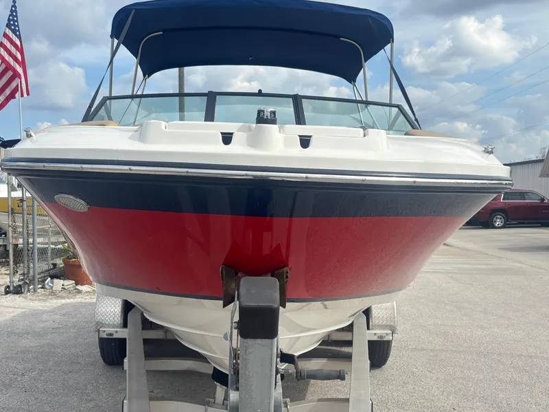 Slide: The Image of 2021 Sea Ray SPX 230 boat on trailer, red and blue hull, American flag in background. - 9