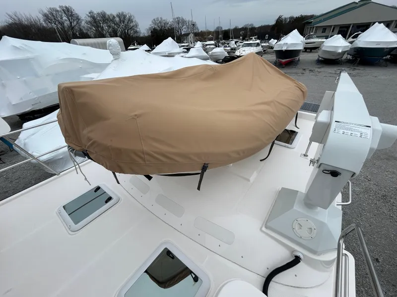 Slide: The Image of 2023 Ranger Tugs R-43 CB boat with covered equipment on deck, surrounded by other boats. - 13