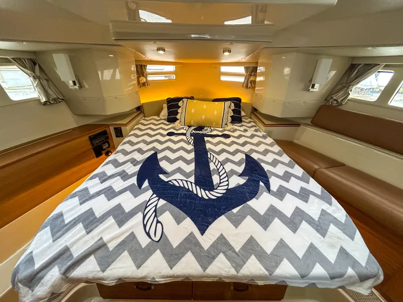 Slide: The Image of 2023 Ranger Tugs R-43 CB cabin with anchor-themed bedding and cozy interior design. - 22