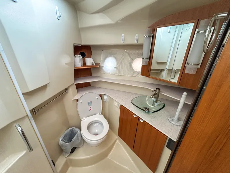 Slide: The Image of 2023 Ranger Tugs R-43 CB bathroom with modern fixtures and wood cabinetry. - 25