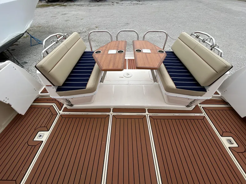 Slide: The Image of 2023 Ranger Tugs R-43 CB boat deck with cushioned seating and wooden tables. - 5
