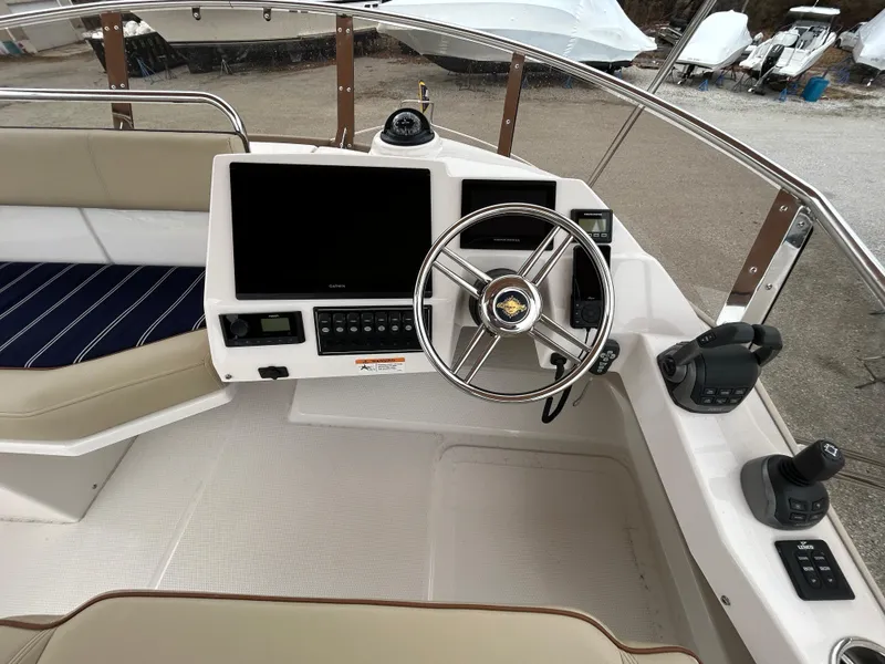 Slide: The Image of 2023 Ranger Tugs R-43 CB helm with steering wheel, navigation screens, and controls. - 8