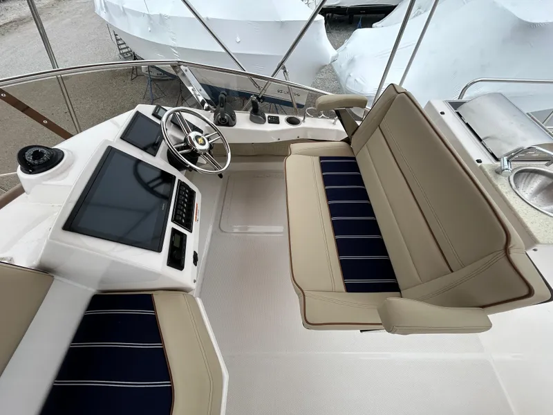 Slide: The Image of 2023 Ranger Tugs R-43 CB helm with dual screens and beige seating. - 9