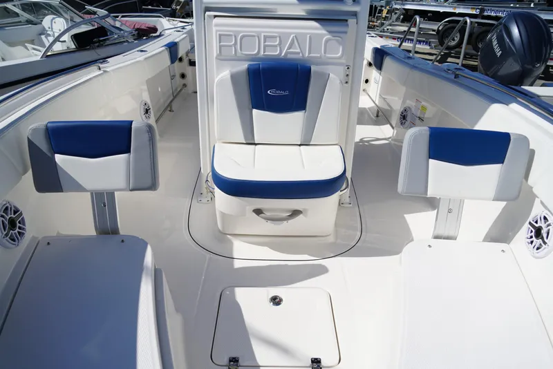 Slide: The Image of 2025 Robalo R232 EX boat interior with blue and white seating. - 11