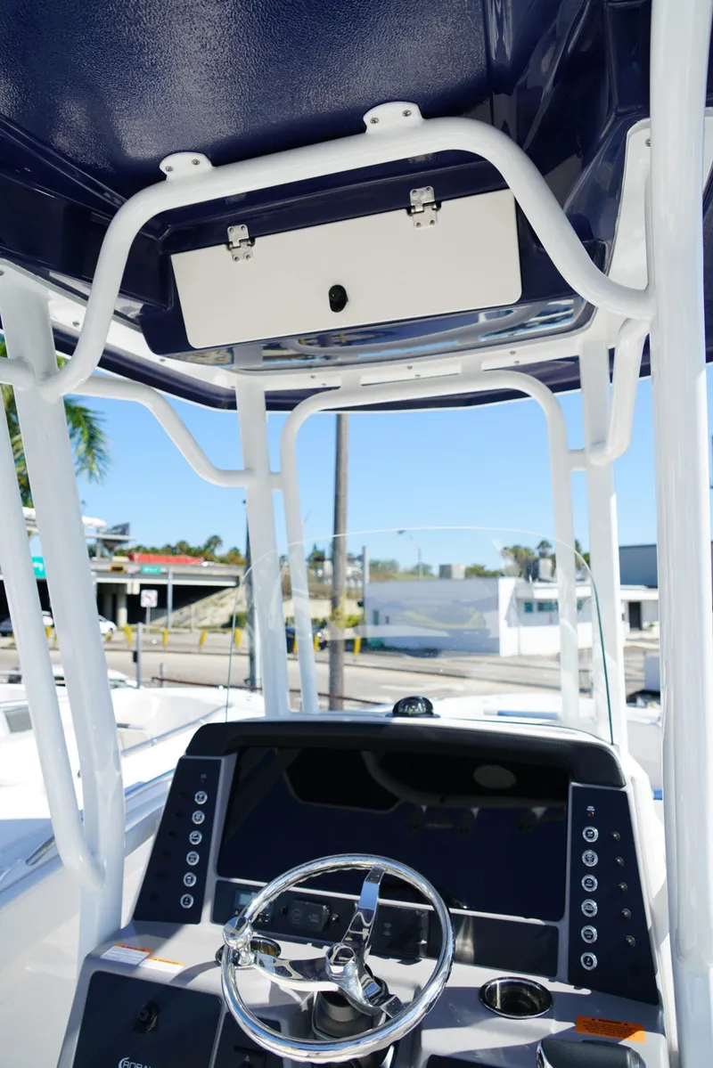 Slide: The Image of 2025 Robalo R232 EX boat helm with steering wheel and control panel. - 22