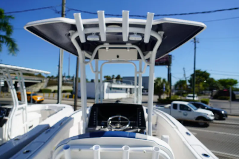 Slide: The Image of 2025 Robalo R232 EX boat with T-top, parked outdoors on a sunny day. - 5