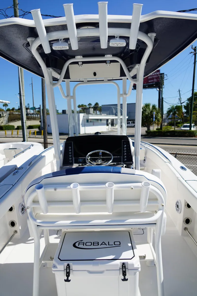 Slide: The Image of 2025 Robalo R232 EX boat interior with steering console and rod holders. - 7