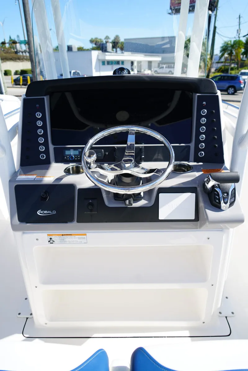 Slide: The Image of 2025 Robalo R232 EX boat dashboard with steering wheel and control panel. - 8
