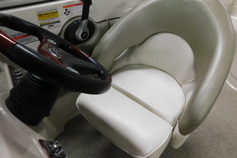 Slide: The Image of 2007 Sea Ray 220 Sundeck helm with steering wheel and cushioned seat. - 18