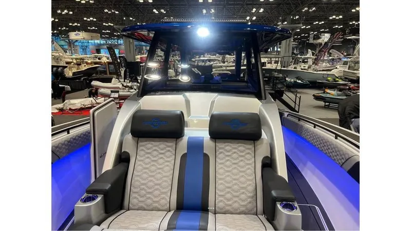 Slide: The Image of 2025 Fountain 43 SCX boat interior with blue accents and luxurious seating at a boat show. - 11