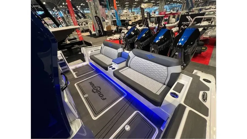 Slide: The Image of 2025 Fountain 43 SCX boat interior with modern seating and ambient lighting at a boat show. - 14