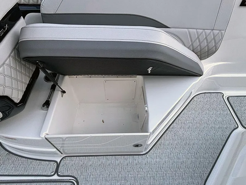 Slide: The Image of 2025 Sea Ray SLX 260 Outboard storage compartment with gray seating and textured flooring. - 12