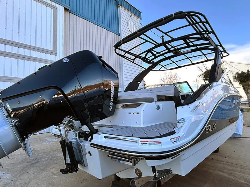 Slide: The Image of 2025 Sea Ray SLX 260 Outboard boat with Mercury engine, docked outdoors. - 2