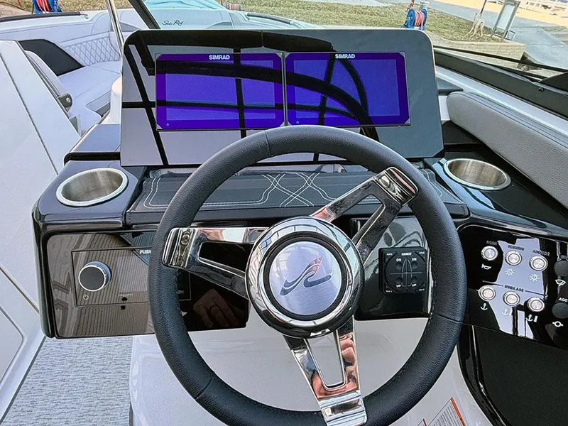 Slide: The Image of 2025 Sea Ray SLX 260 Outboard dashboard with modern steering and dual Simrad displays. - 25