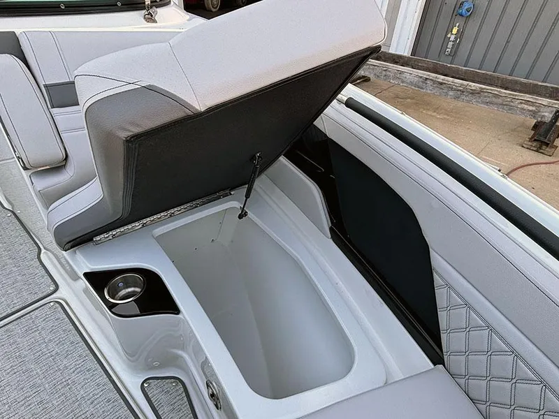 Slide: The Image of 2025 Sea Ray SLX 260 Outboard boat interior with open storage compartment and cup holder. - 32