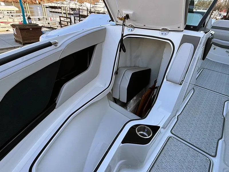 Slide: The Image of 2025 Sea Ray SLX 260 Outboard boat storage compartment with open hatch and seating area. - 33