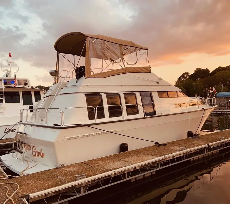 Slide: The Image of 1989 Mainship 41 Grand Salon yacht docked at sunset, featuring a covered upper deck. - 17