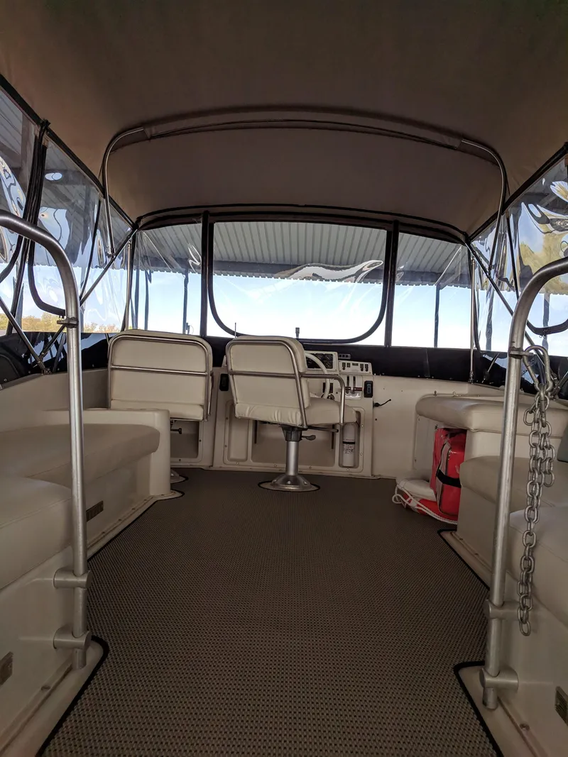 Slide: The Image of 1989 Mainship 41 Grand Salon interior with seating and helm, featuring a covered deck. - 21